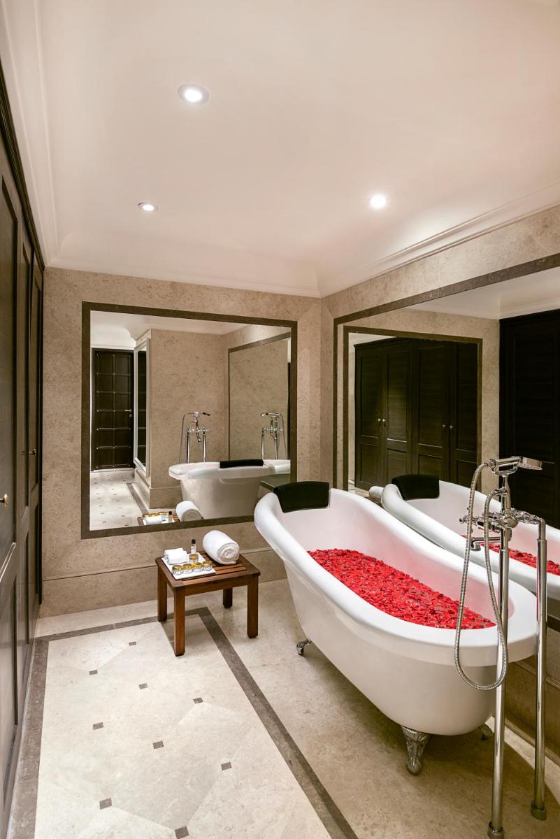 a bathroom with two tubs and a large mirror at Aurika, Udaipur - Luxury by Lemon Tree Hotels in Udaipur