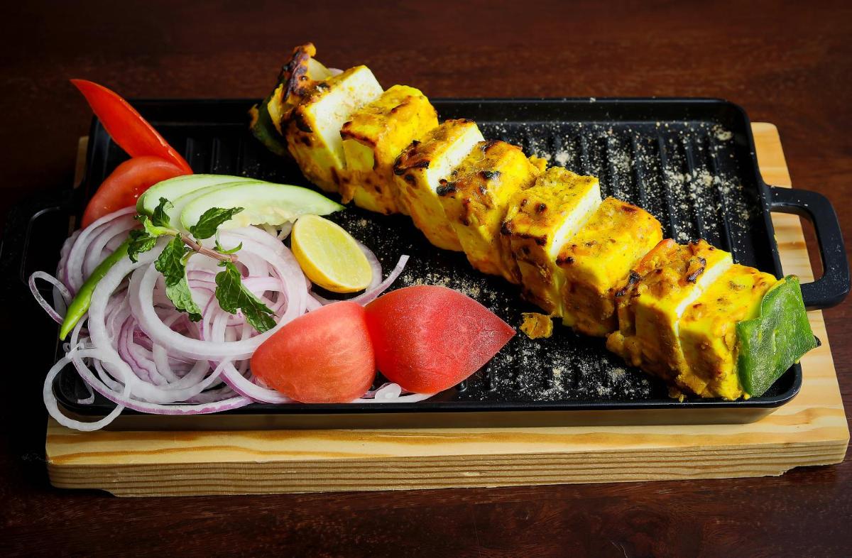 a black plate of food with sushi and vegetables at Welcomhotel by ITC Hotels, Shimla in Shimla