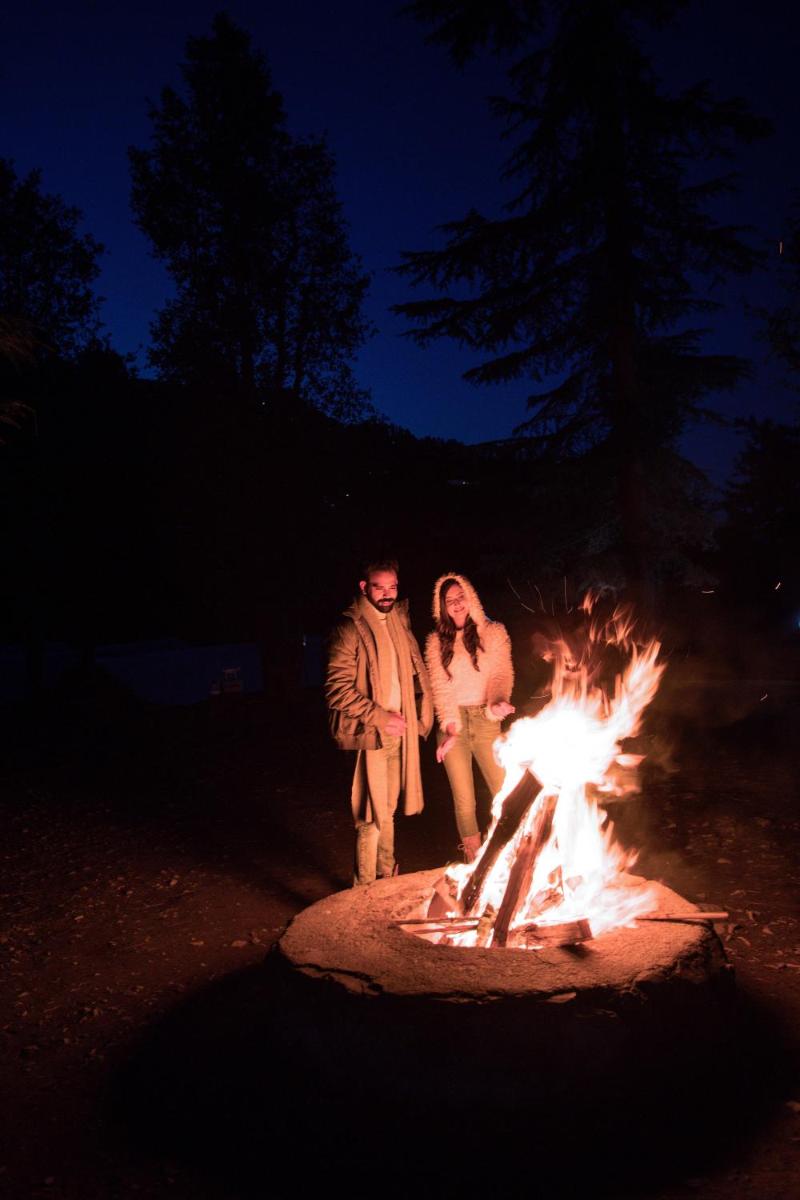 a man and a woman standing next to a fire at Welcomhotel by ITC Hotels, Shimla in Shimla