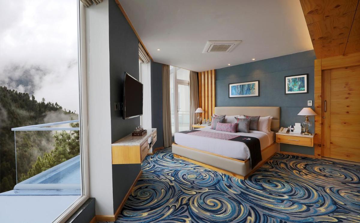 a hotel room with a bed and a large window at Welcomhotel by ITC Hotels, Shimla in Shimla