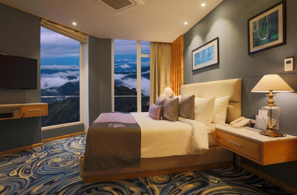 a bedroom with a bed and a large window at Welcomhotel by ITC Hotels, Shimla in Shimla