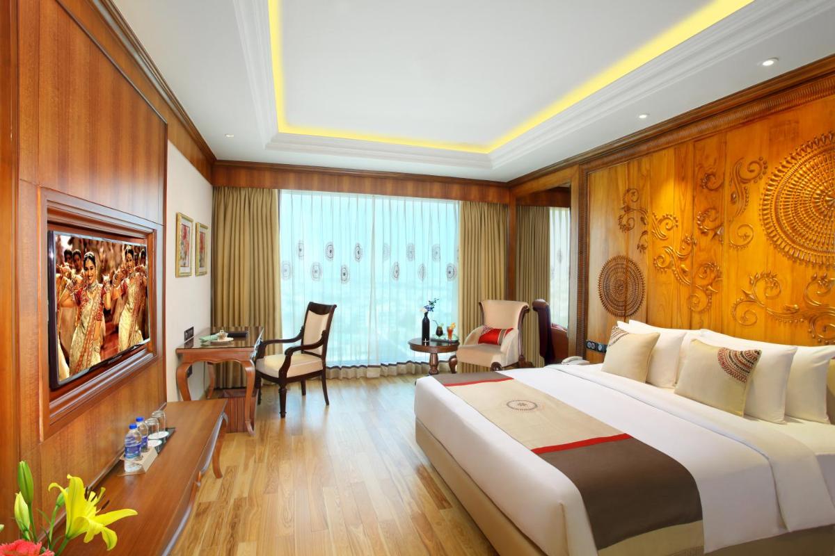 a hotel room with a large bed and a desk at Seven Seas Hotel in New Delhi