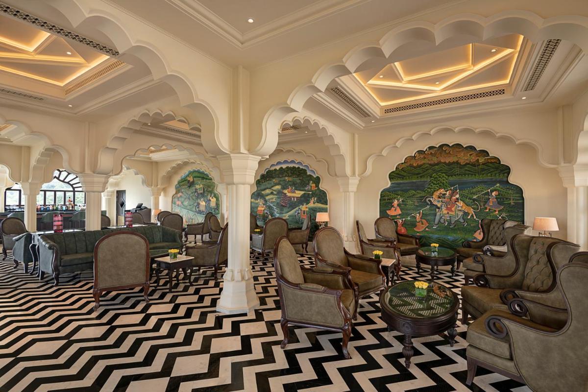 a lobby with chairs and paintings on the walls at Aurika, Udaipur - Luxury by Lemon Tree Hotels in Udaipur