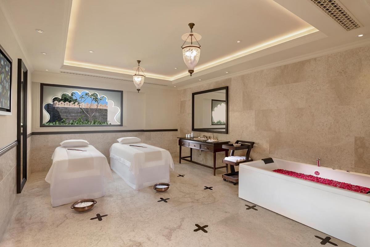 a living room with white furniture and a table at Aurika, Udaipur - Luxury by Lemon Tree Hotels in Udaipur