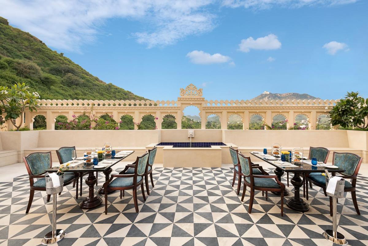 a patio with tables and chairs on a checkered floor at Aurika, Udaipur - Luxury by Lemon Tree Hotels in Udaipur