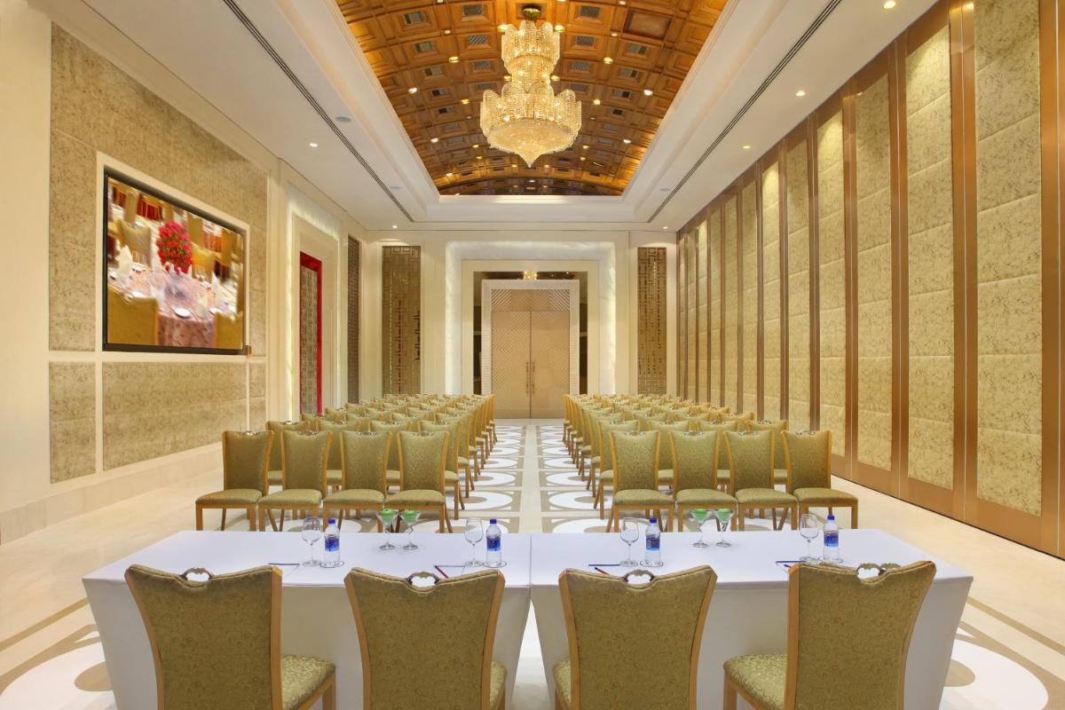 a conference room with a large white table and chairs at Seven Seas Hotel in New Delhi