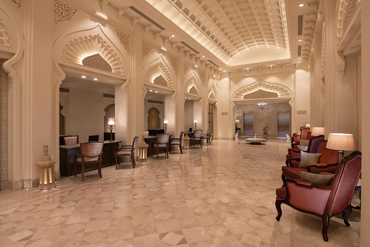 a lobby with chairs and tables in a building at Aurika, Udaipur - Luxury by Lemon Tree Hotels in Udaipur