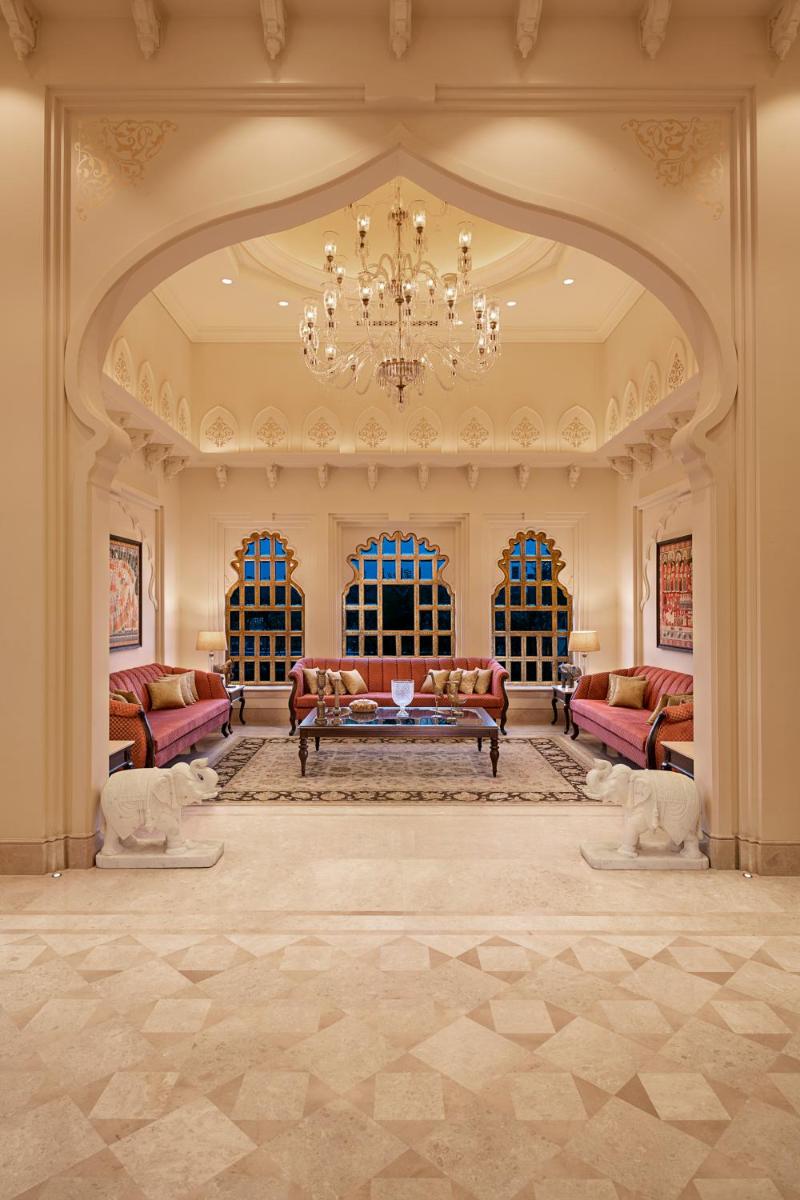 a large living room with a couch and a chandelier at Aurika, Udaipur - Luxury by Lemon Tree Hotels in Udaipur