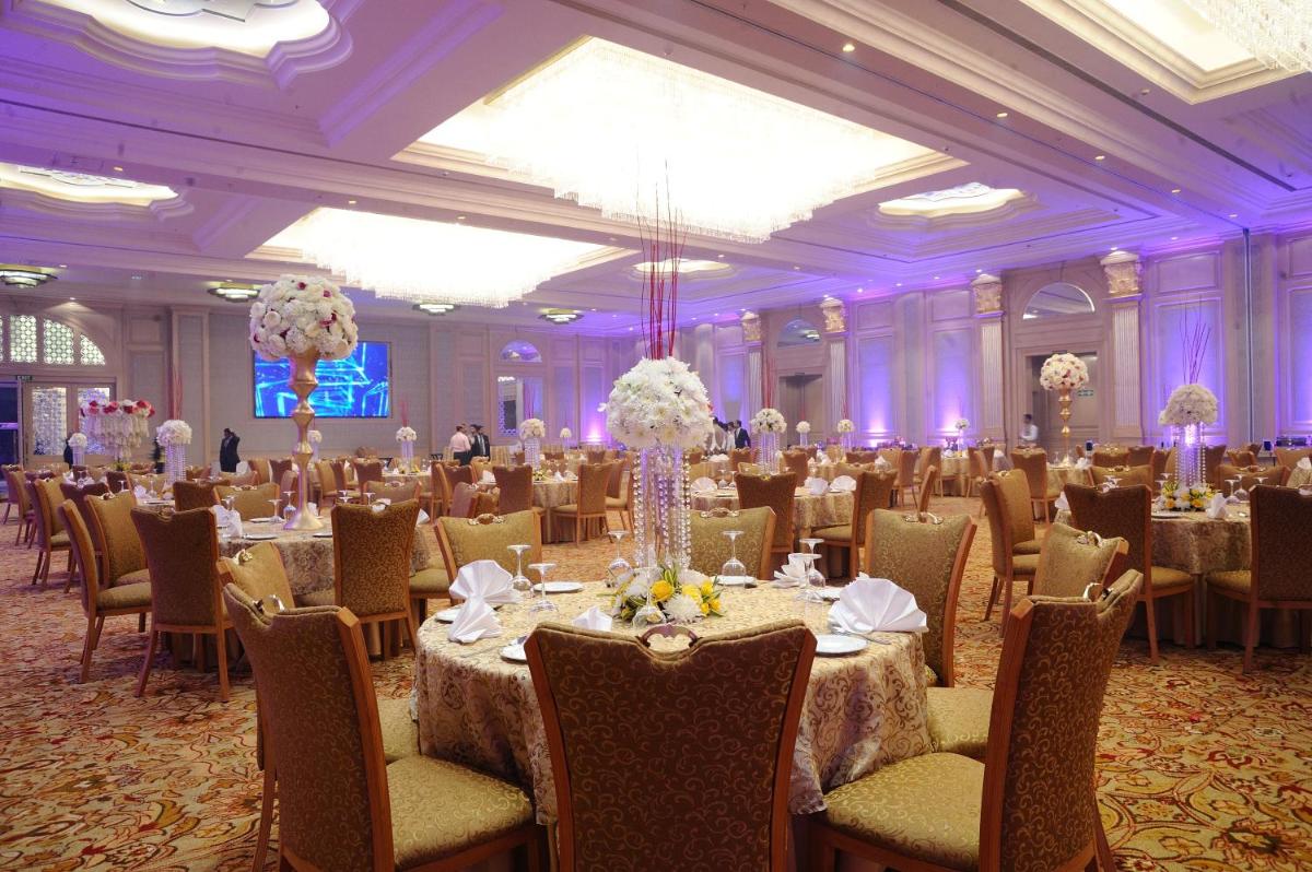 a ballroom with tables and chairs in a room with purple lighting at Seven Seas Hotel in New Delhi