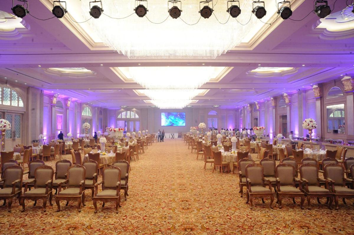 a banquet hall with tables and chairs in a room with purple lighting at Seven Seas Hotel in New Delhi