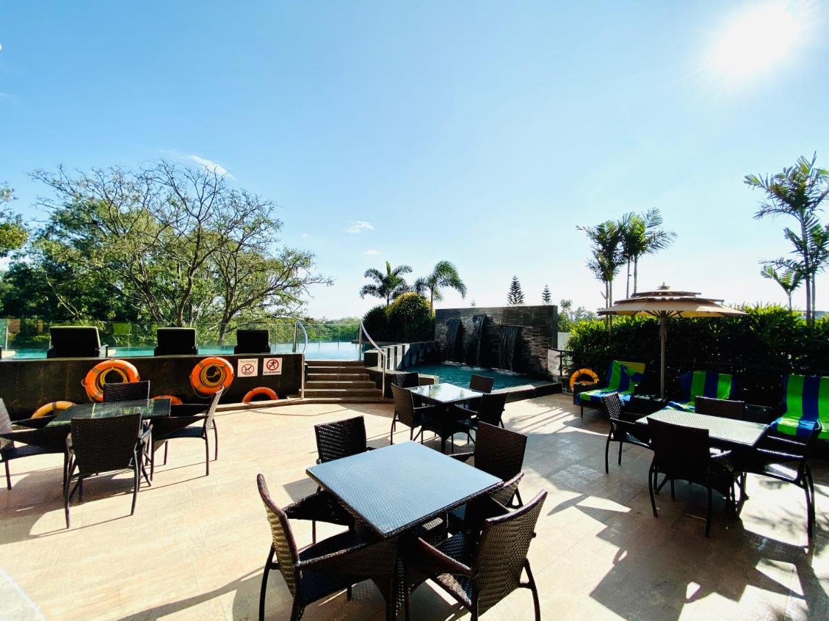 a patio with tables and chairs on a deck at Welcomhotel by ITC Hotels, Richmond Road, Bengaluru in Bengaluru