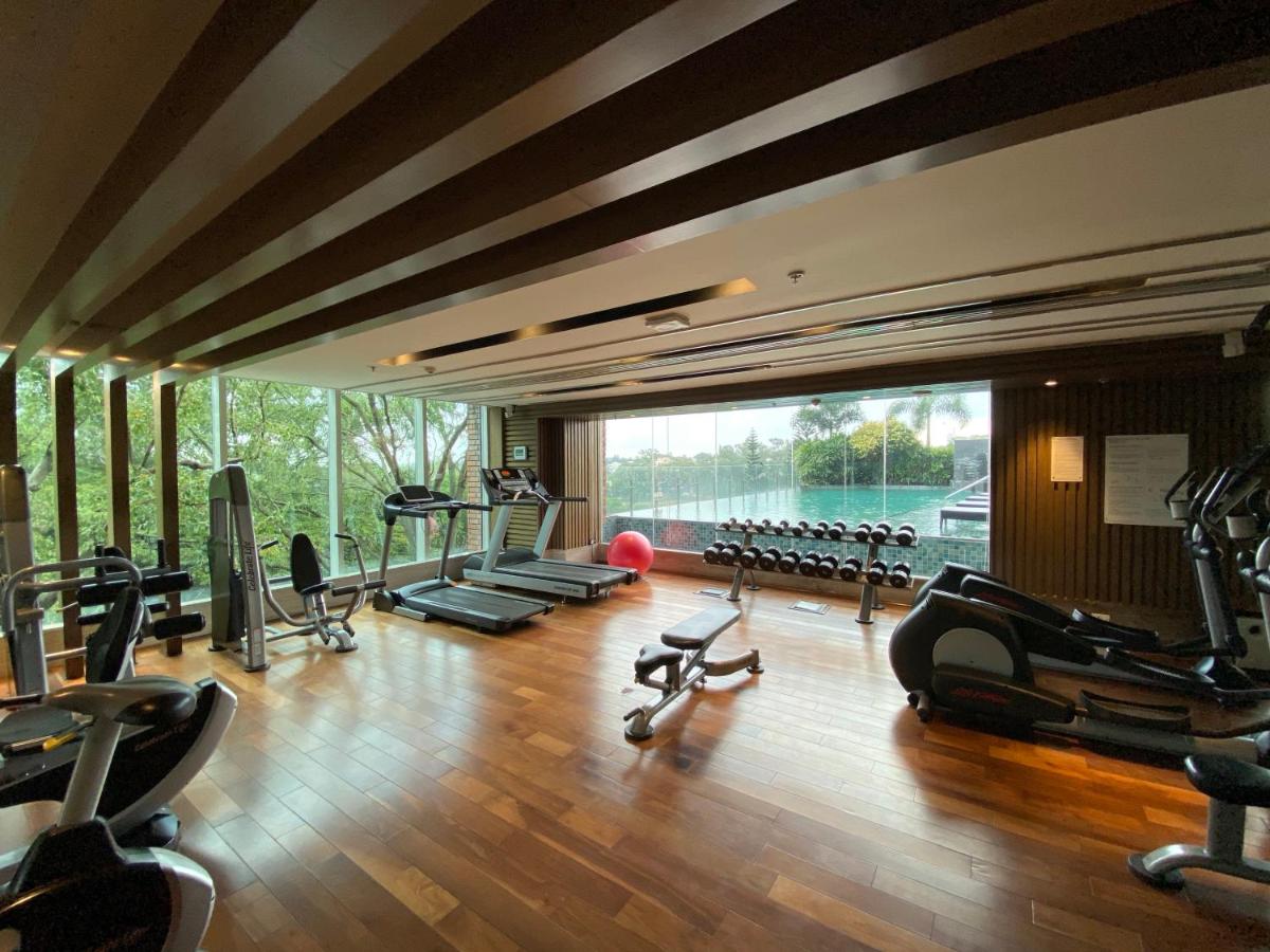 a gym with exercise equipment and a large window at Welcomhotel by ITC Hotels, Richmond Road, Bengaluru in Bengaluru
