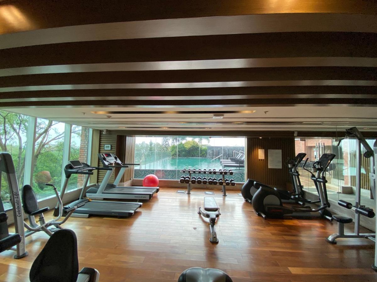 a gym with tread machines and a large window at Welcomhotel by ITC Hotels, Richmond Road, Bengaluru in Bengaluru