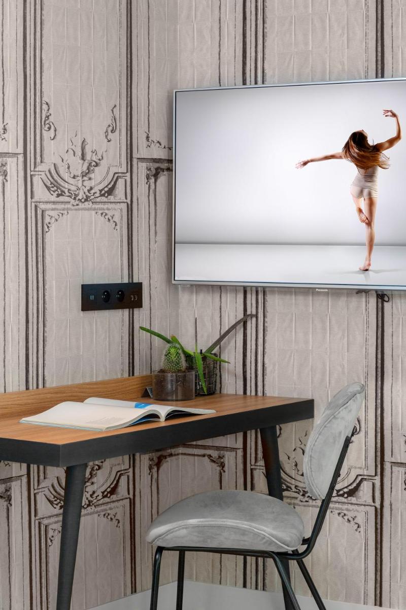 Télévision ou salle de divertissement dans l'établissement Lyric Hotel Paris Opera