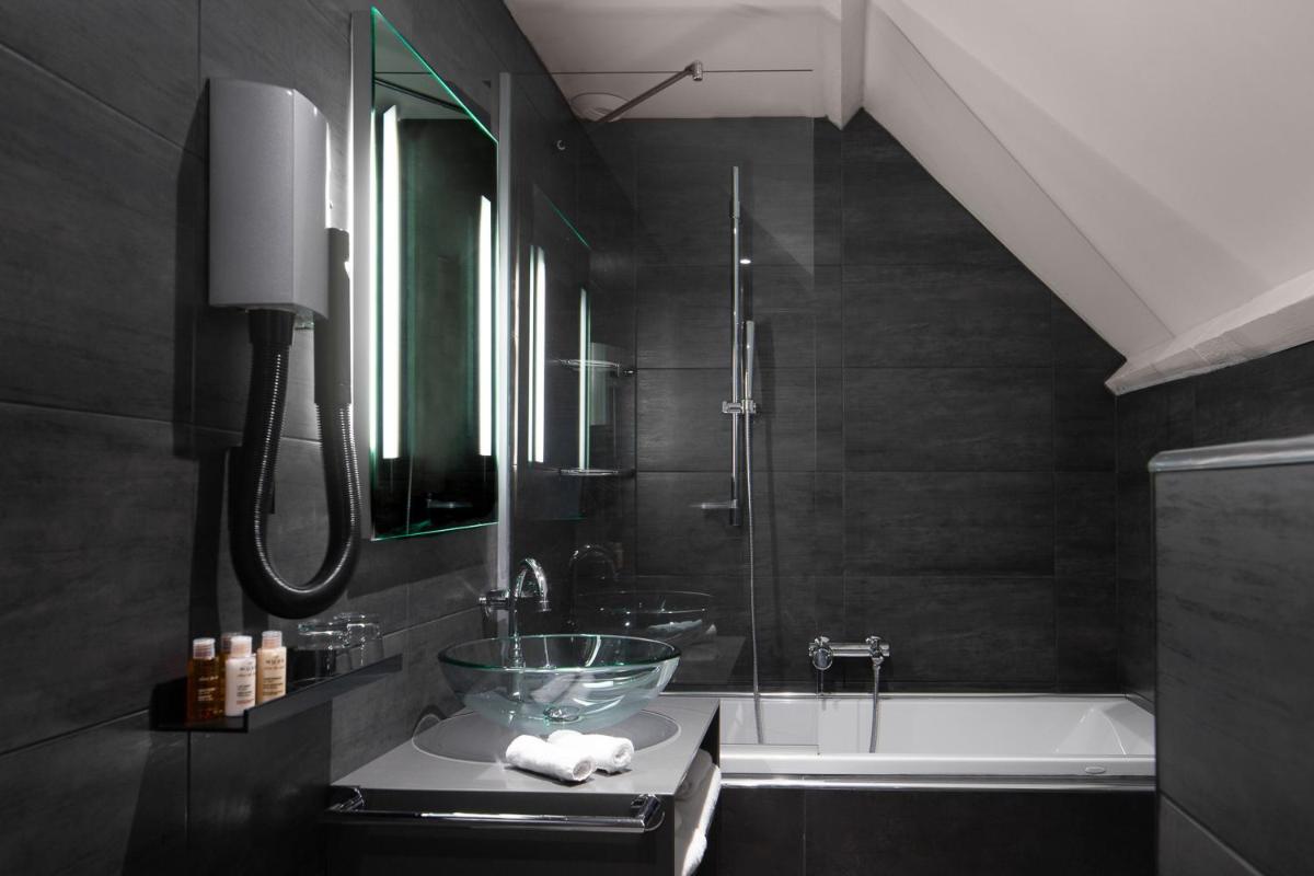 une salle de bains avec lavabo et baignoire dans l'établissement Lyric Hotel Paris Opera, à Paris