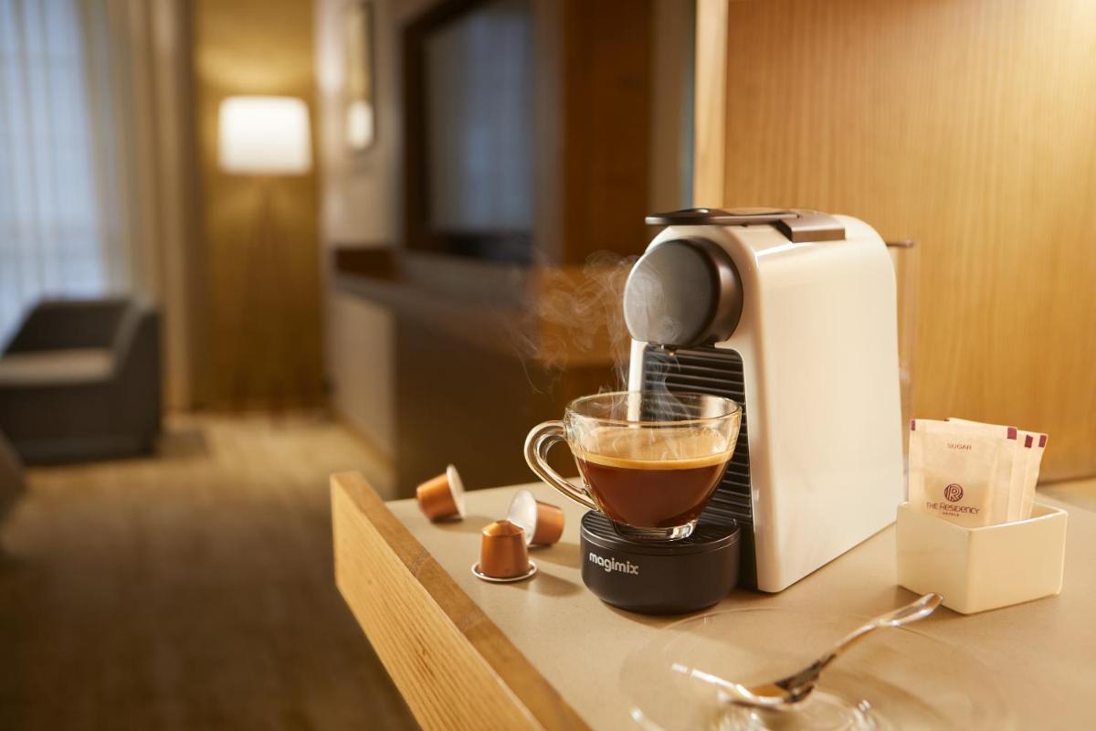 a coffee maker sitting on a counter with a cup of coffee at The Residency Towers in Chennai