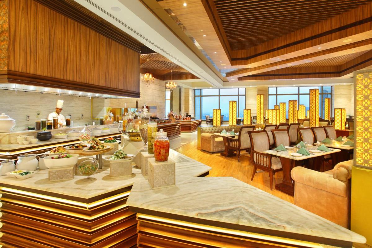 a dining room with tables and chairs in a restaurant at Seven Seas Hotel in New Delhi