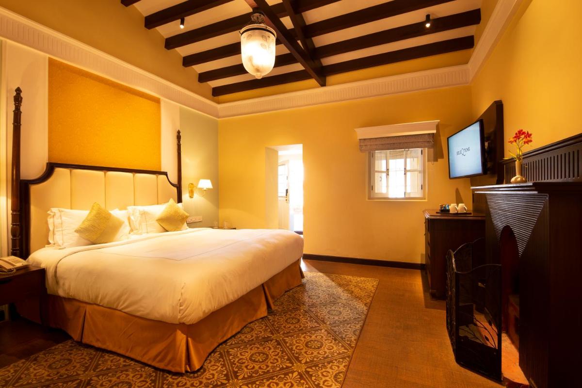 a bedroom with a large bed and a television at Savoy - IHCL SeleQtions in Ooty