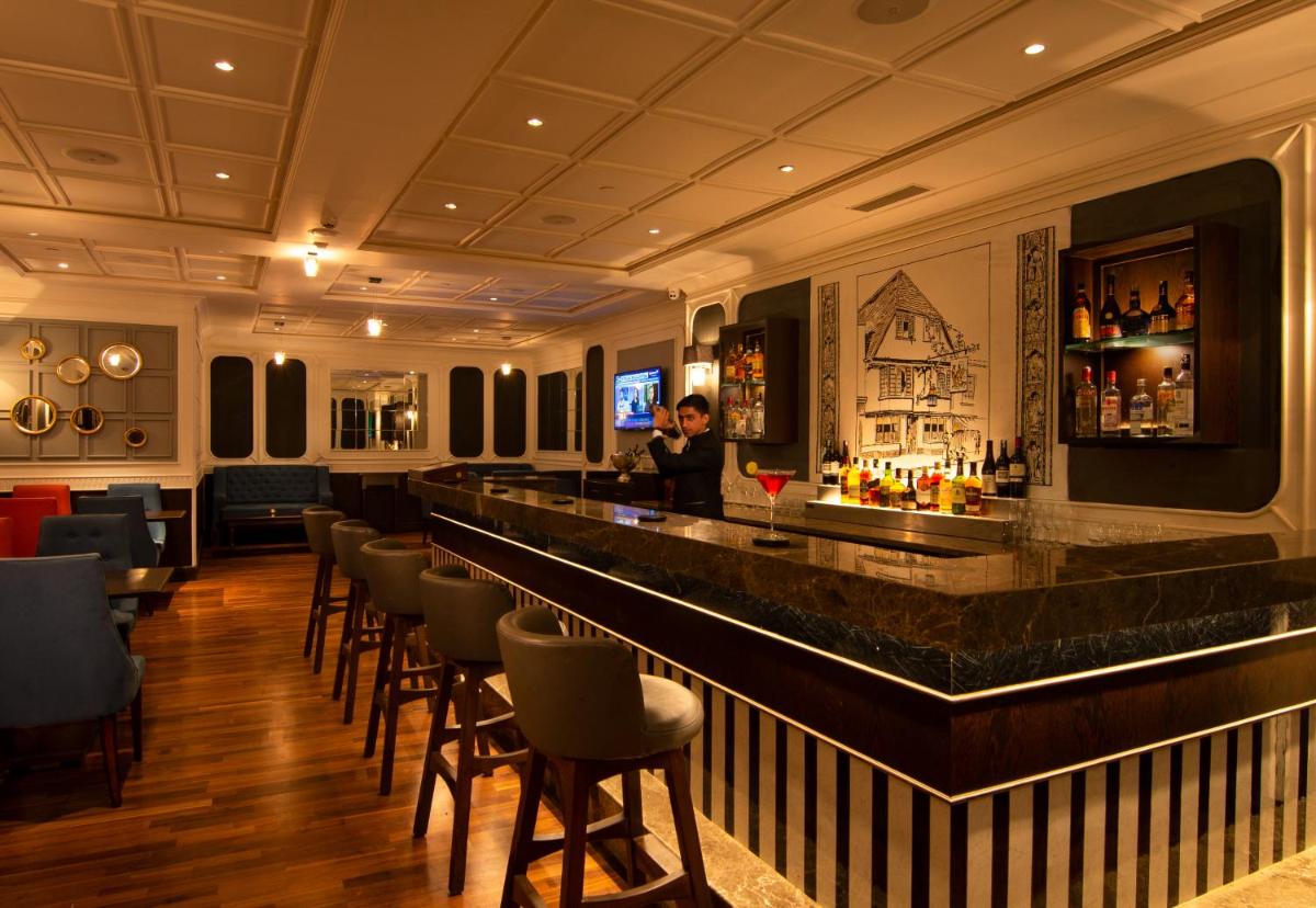 a bar in a hotel with a man standing behind it at Savoy - IHCL SeleQtions in Ooty