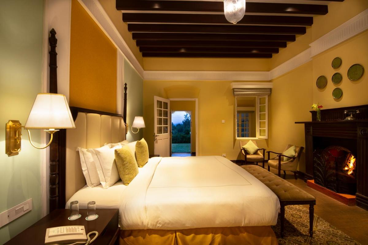 a bedroom with a large bed and a fireplace at Savoy - IHCL SeleQtions in Ooty