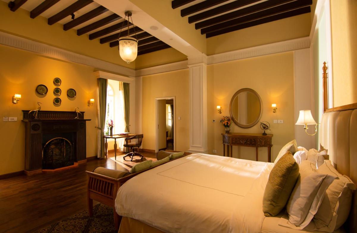 a bedroom with a large bed and a fireplace at Savoy - IHCL SeleQtions in Ooty +127 photos