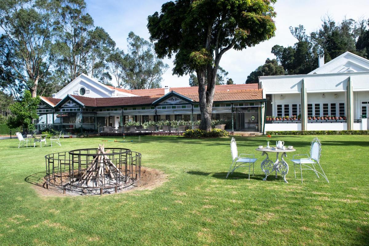 a building with a table and chairs in a yard at Savoy - IHCL SeleQtions in Ooty