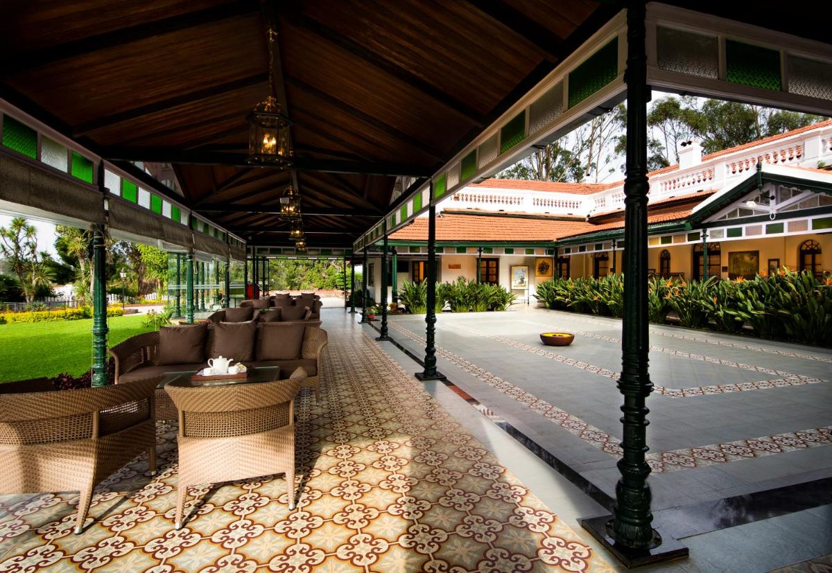 an outdoor pavilion with couches and chairs in a building at Savoy - IHCL SeleQtions in Ooty
