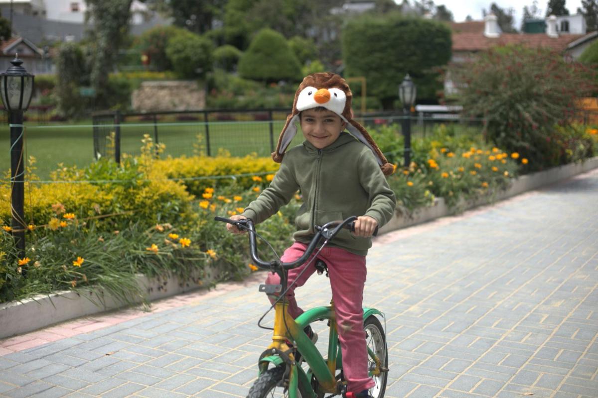 a young child riding a bike with a bird head on it at Savoy - IHCL SeleQtions in Ooty