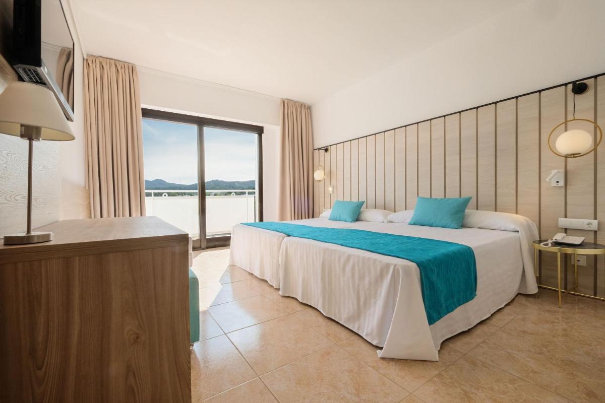 Un dormitorio con una cama grande y una ventana grande. en azuLine Hotel Bergantin, en Bahía de San Antonio