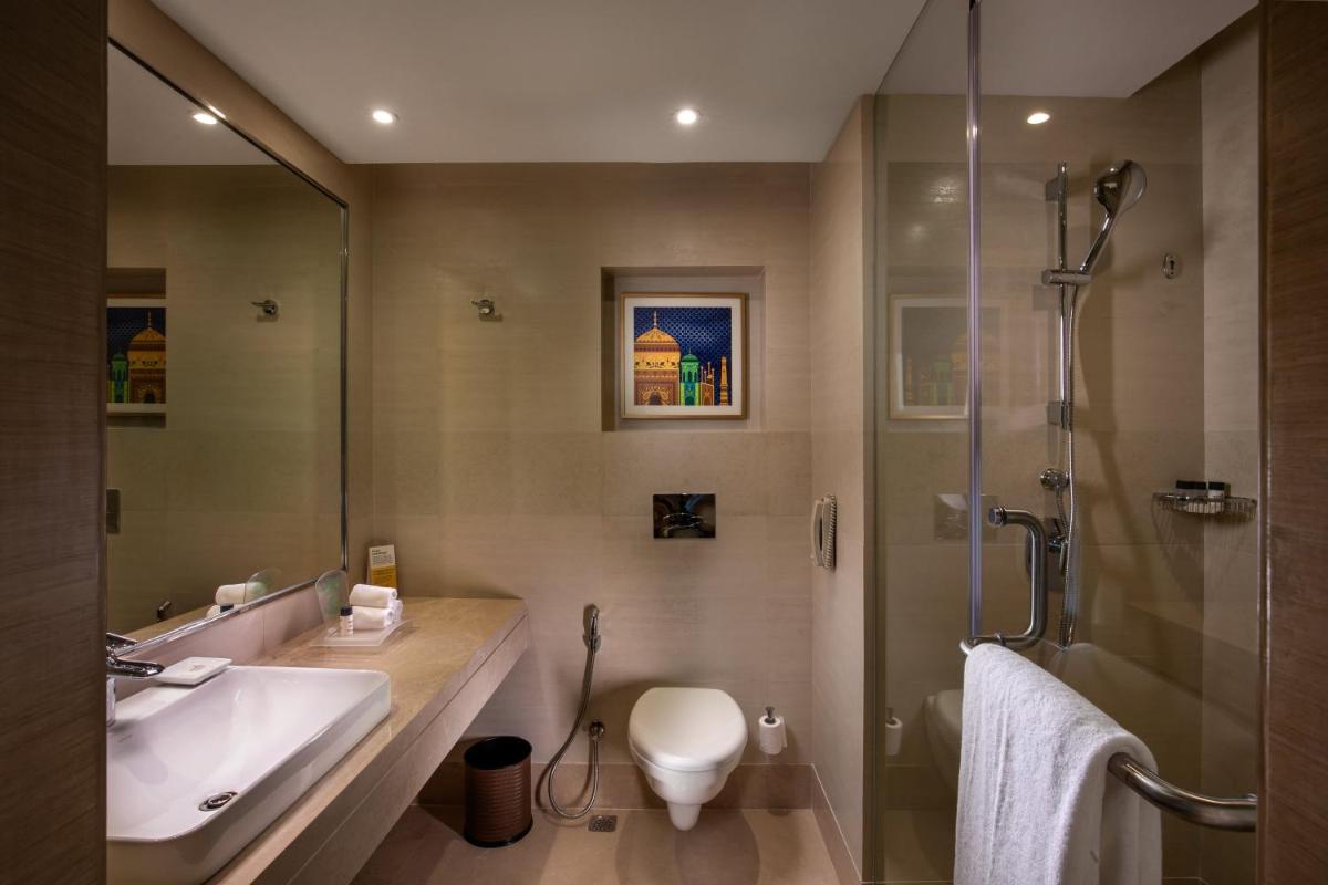 a bathroom with a toilet and a sink and a shower at Holiday Inn Agra MG Road an IHG Hotel in Agra
