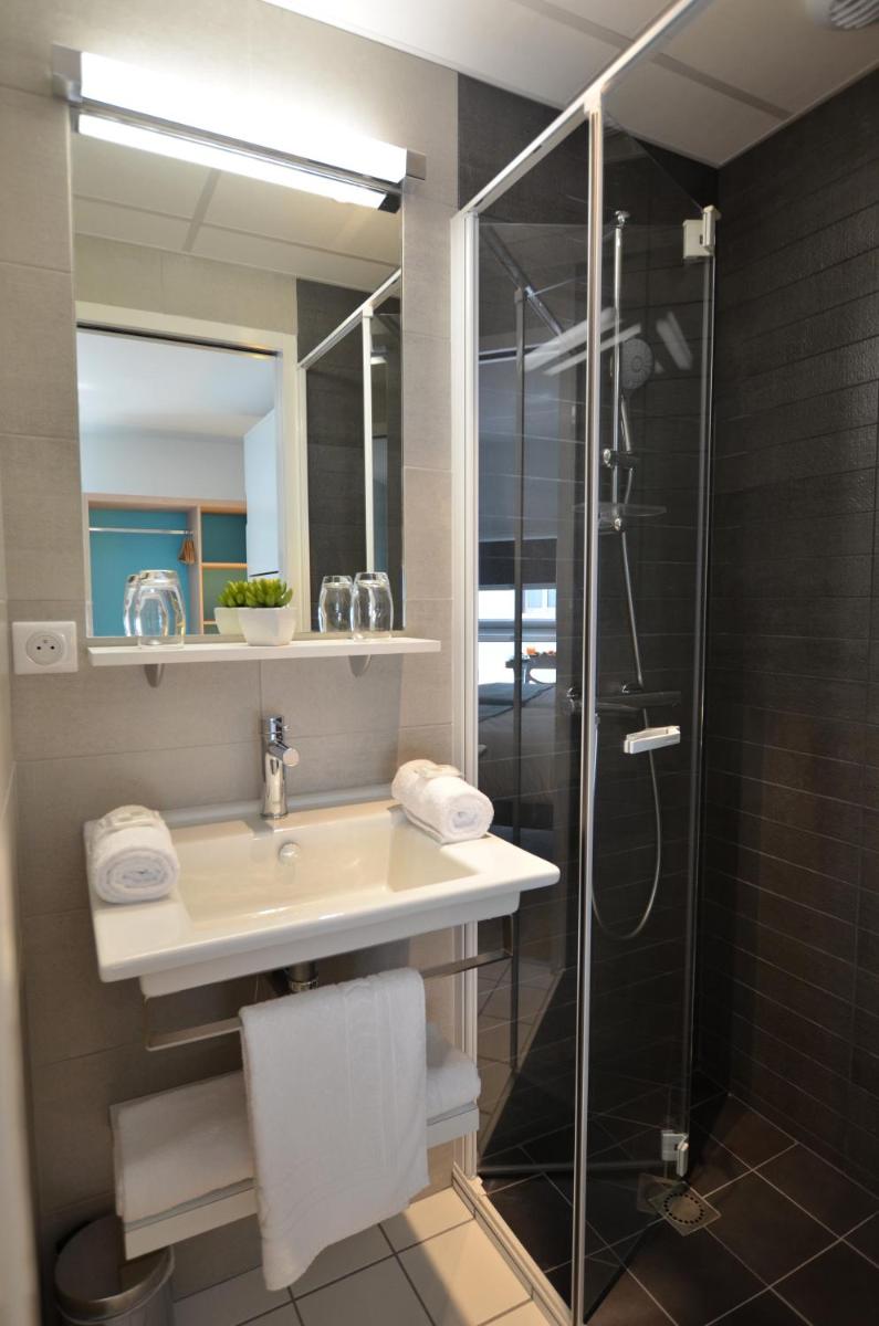 une salle de bain avec un lavabo et une douche en verre dans l'établissement TERNELIA Le Vent Du Large, à Saint-Gilles-Croix-de-Vie 50 autres photos