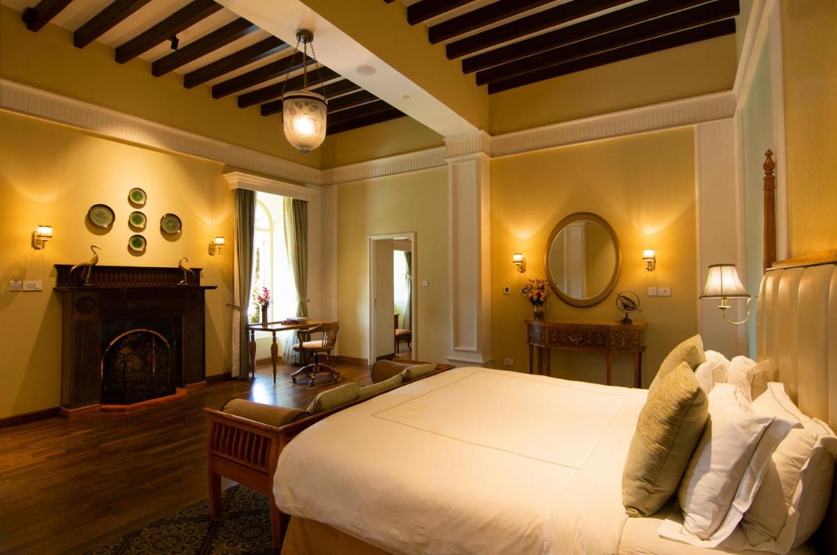 a bedroom with a large bed and a fireplace at Savoy - IHCL SeleQtions in Ooty