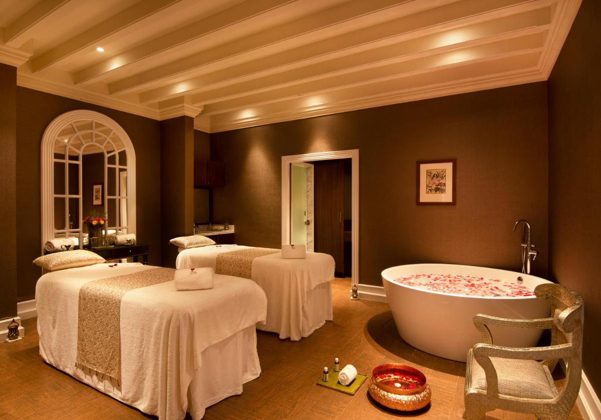 a bathroom with two beds and a bath tub at Savoy - IHCL SeleQtions in Ooty