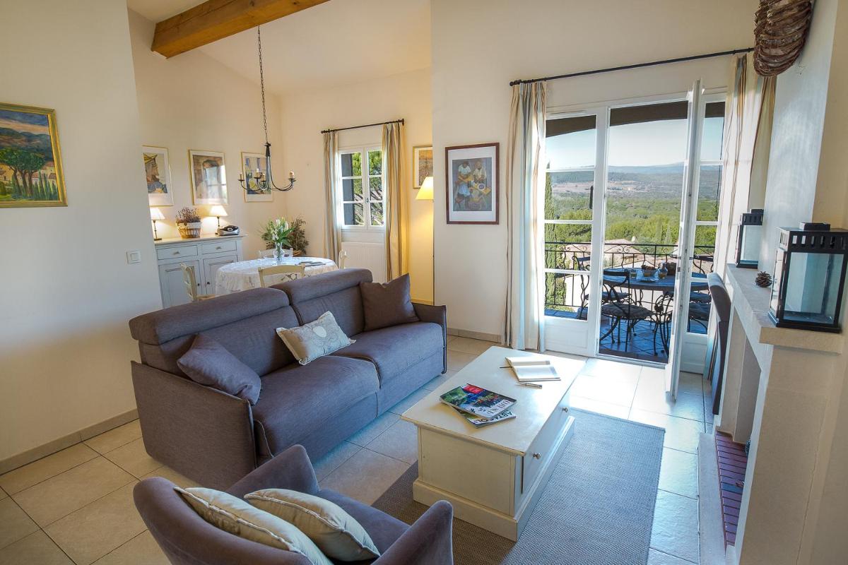 un salon avec un canapé et une table dans l'établissement Les Appartements et Maisons du Domaine de Saint Endréol Golf & Spa Resort, à La Motte