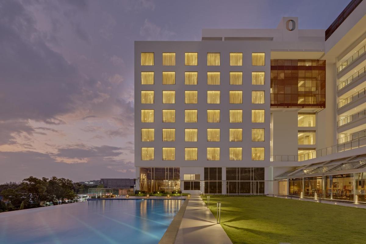 an exterior view of a hotel with a swimming pool at O by Tamara, Trivandrum in Trivandrum