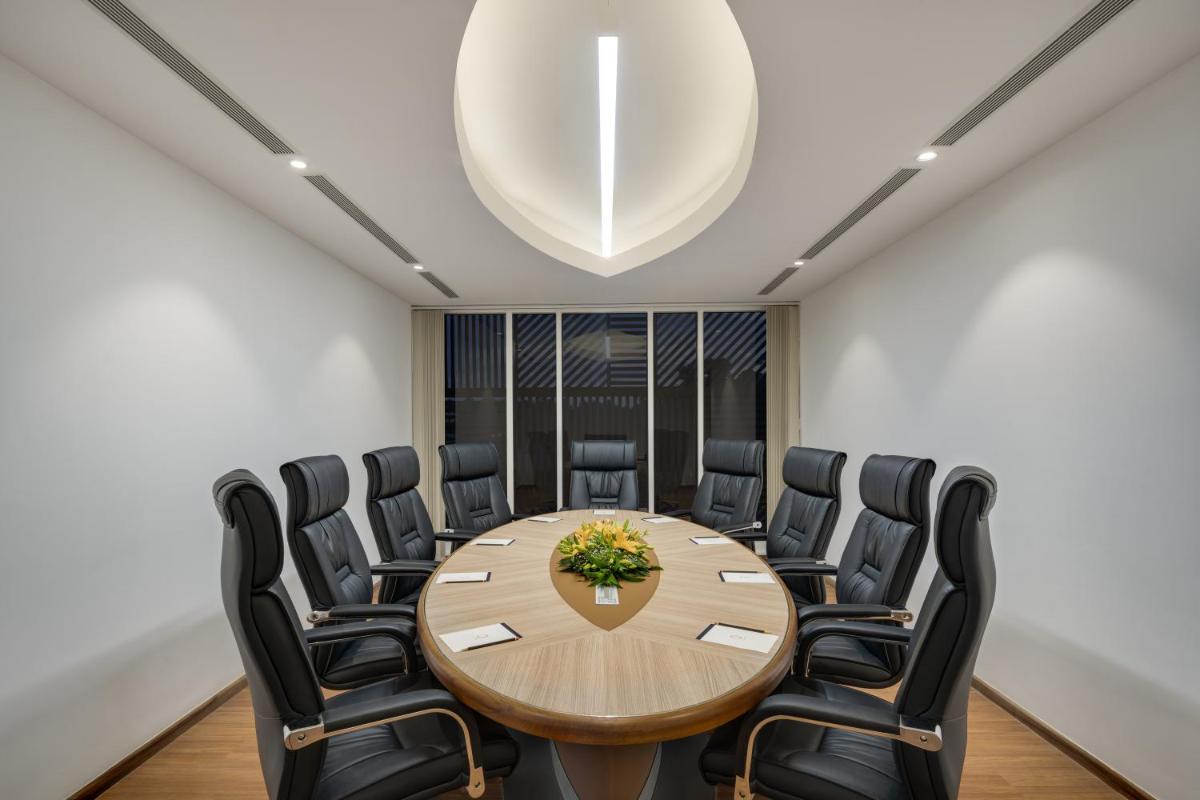 a conference room with a wooden table and chairs at O by Tamara, Trivandrum in Trivandrum