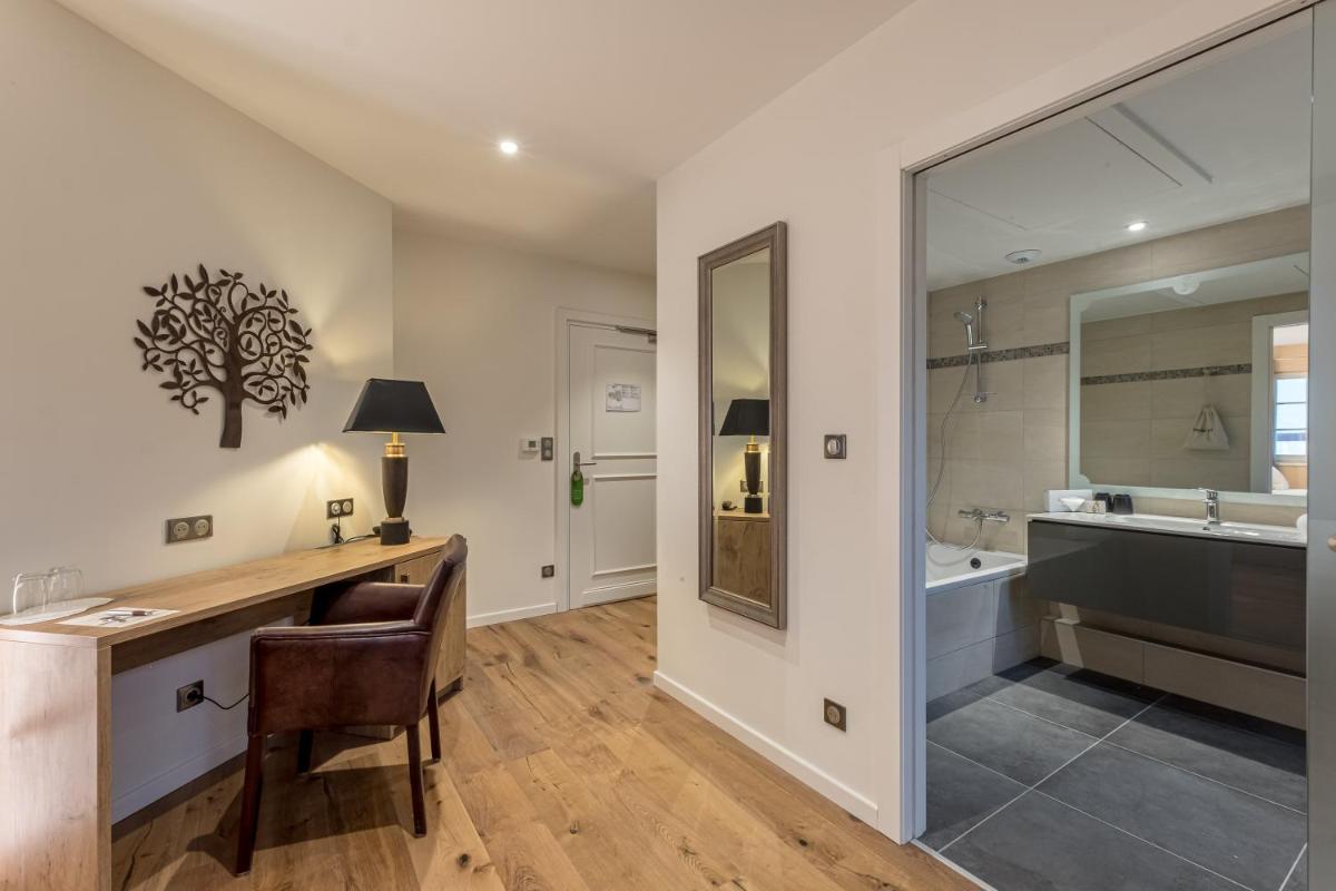 une salle de bains avec un bureau, un lavabo et un miroir dans l'établissement Château de Pourtalès, à Strasbourg