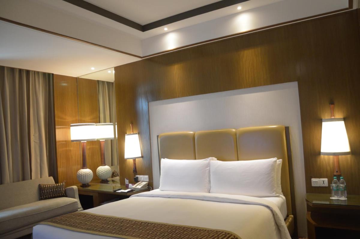 a hotel room with a bed and a chair at Crowne Plaza New Delhi Okhla by IHG in New Delhi