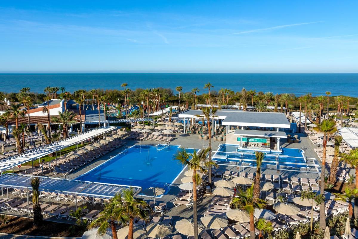Una vista aérea de un resort con piscina y el océano. en Hotel Riu Chiclana - All Inclusive, en Chiclana de la Frontera
