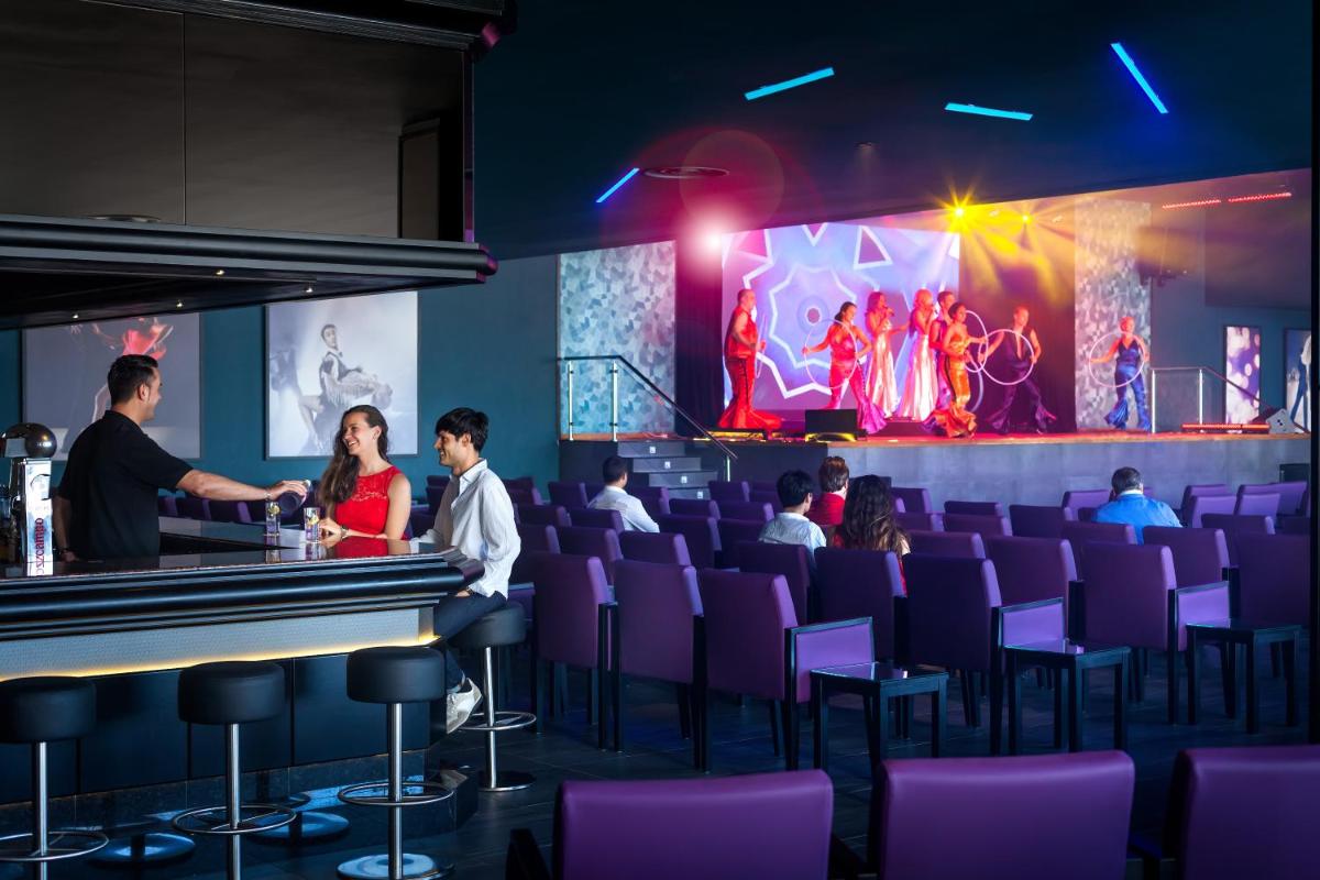 un grupo de personas sentadas en un bar en un teatro en Hotel Riu Chiclana - All Inclusive, en Chiclana de la Frontera 47 fotos más