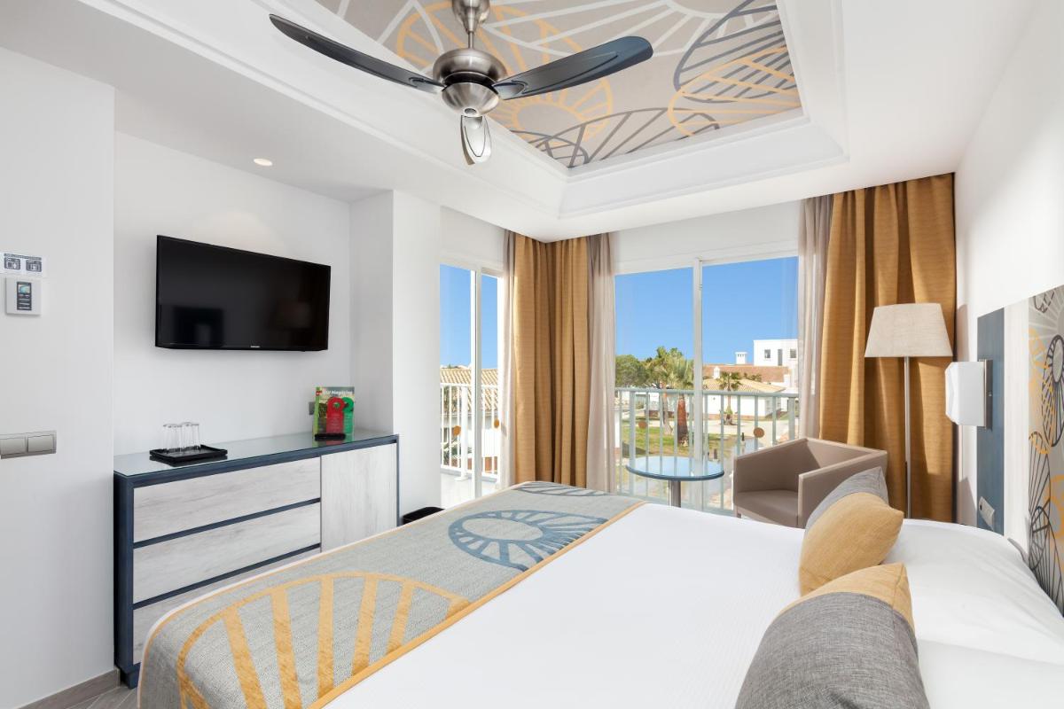 Una habitación de hotel con una cama y un televisor. en Hotel Riu Chiclana - All Inclusive, en Chiclana de la Frontera