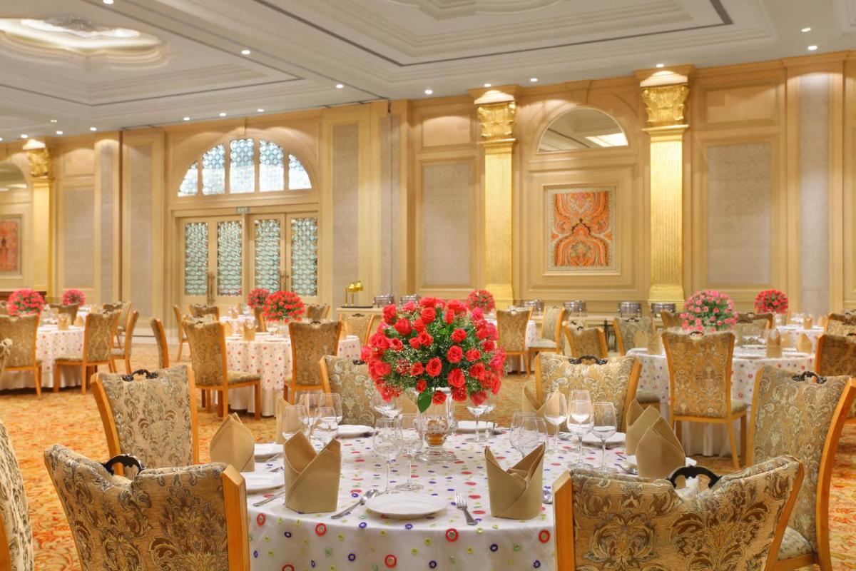 a banquet hall with a table with red flowers at Seven Seas Hotel in New Delhi