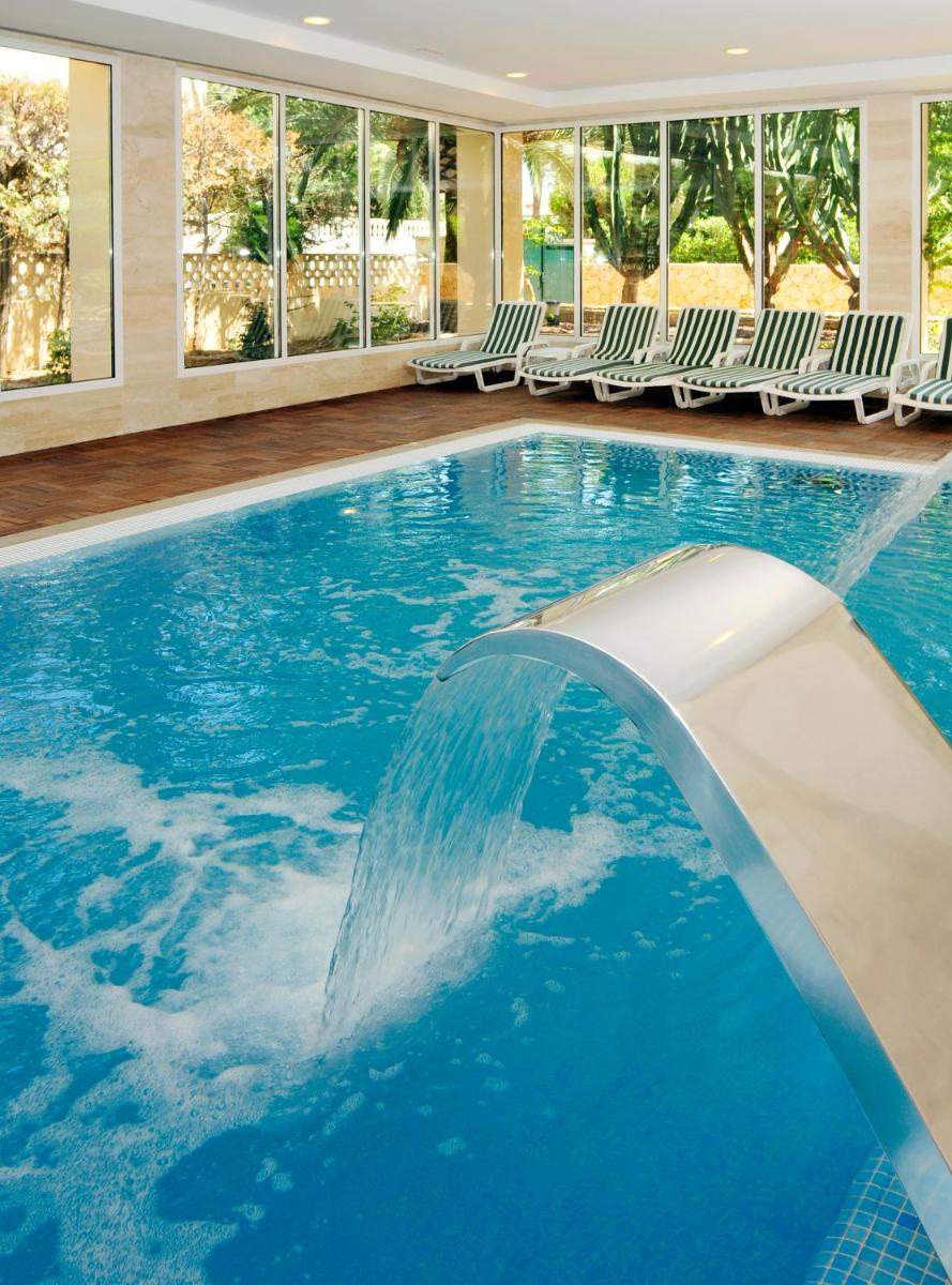 una piscina con cascada en un hotel en Hipotels Said, en Cala Millor