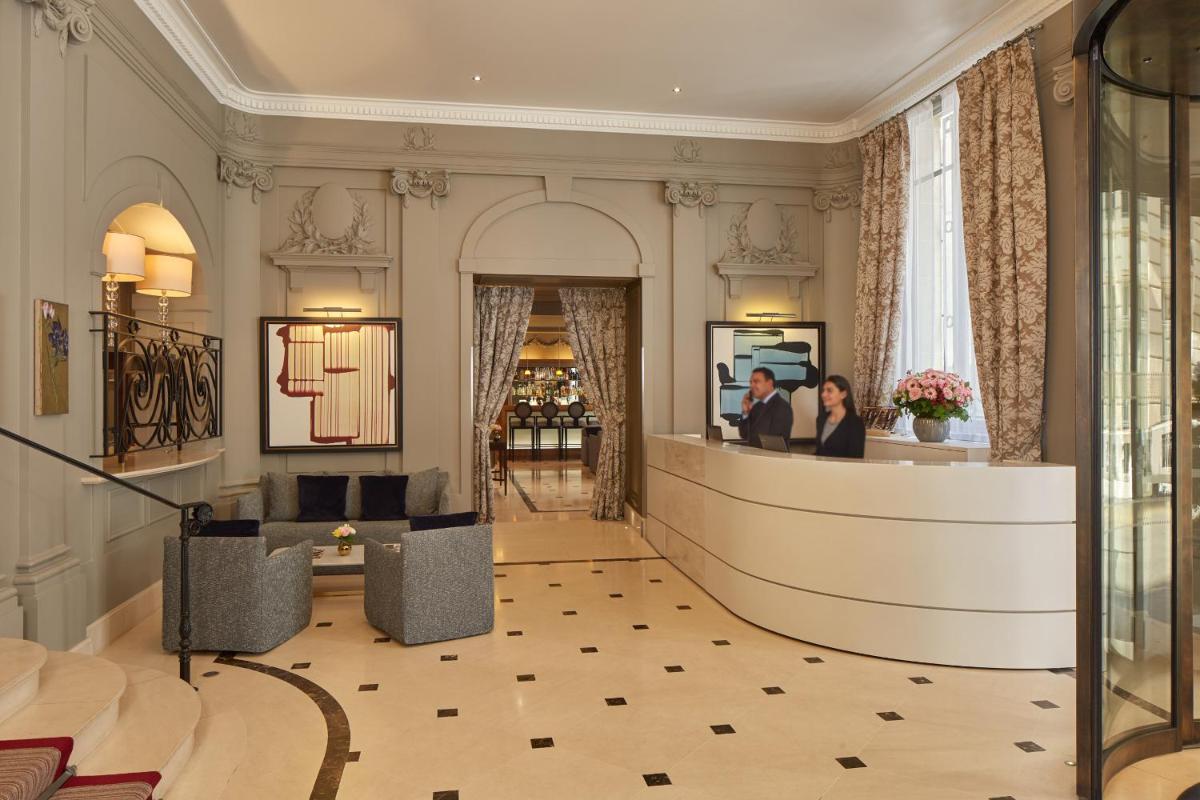 un hall d'entrée avec un bureau de réception dans un immeuble dans l'établissement Majestic Hotel Spa - Champs Elysées, à Paris un hall d'entrée avec un bureau de réception dans un immeuble dans l'établissement Majestic Hotel Spa - Champs Elysées, à Paris