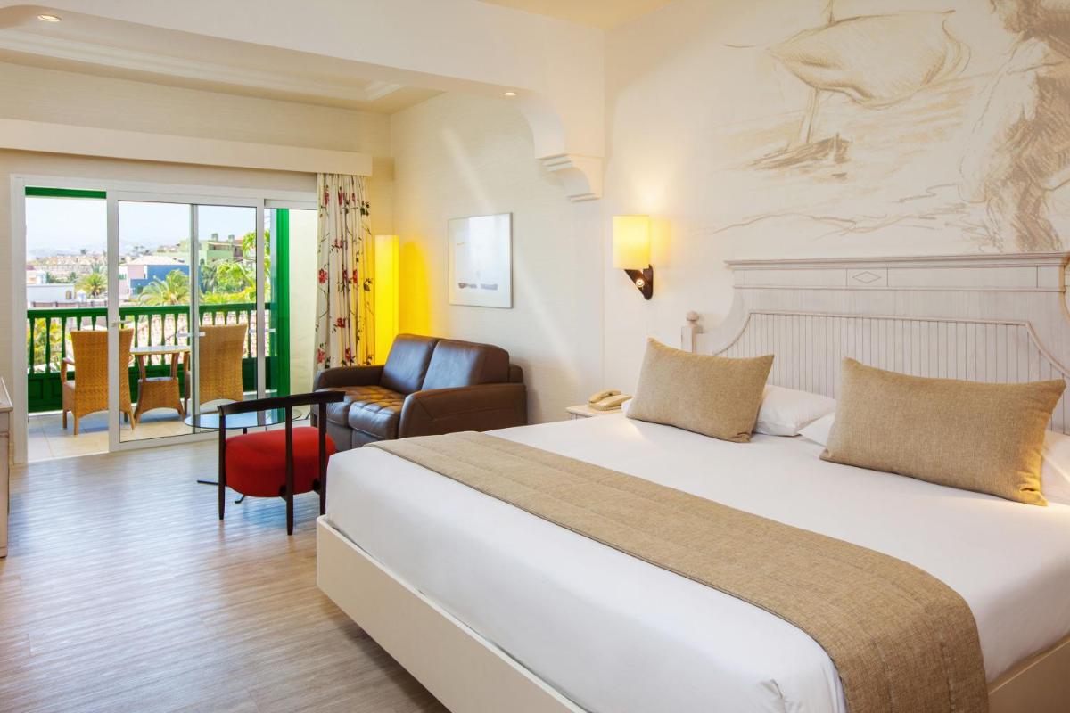 una habitación de hotel con una cama y una silla en Lopesan Villa del Conde Resort & Thalasso, en Meloneras 39 fotos más