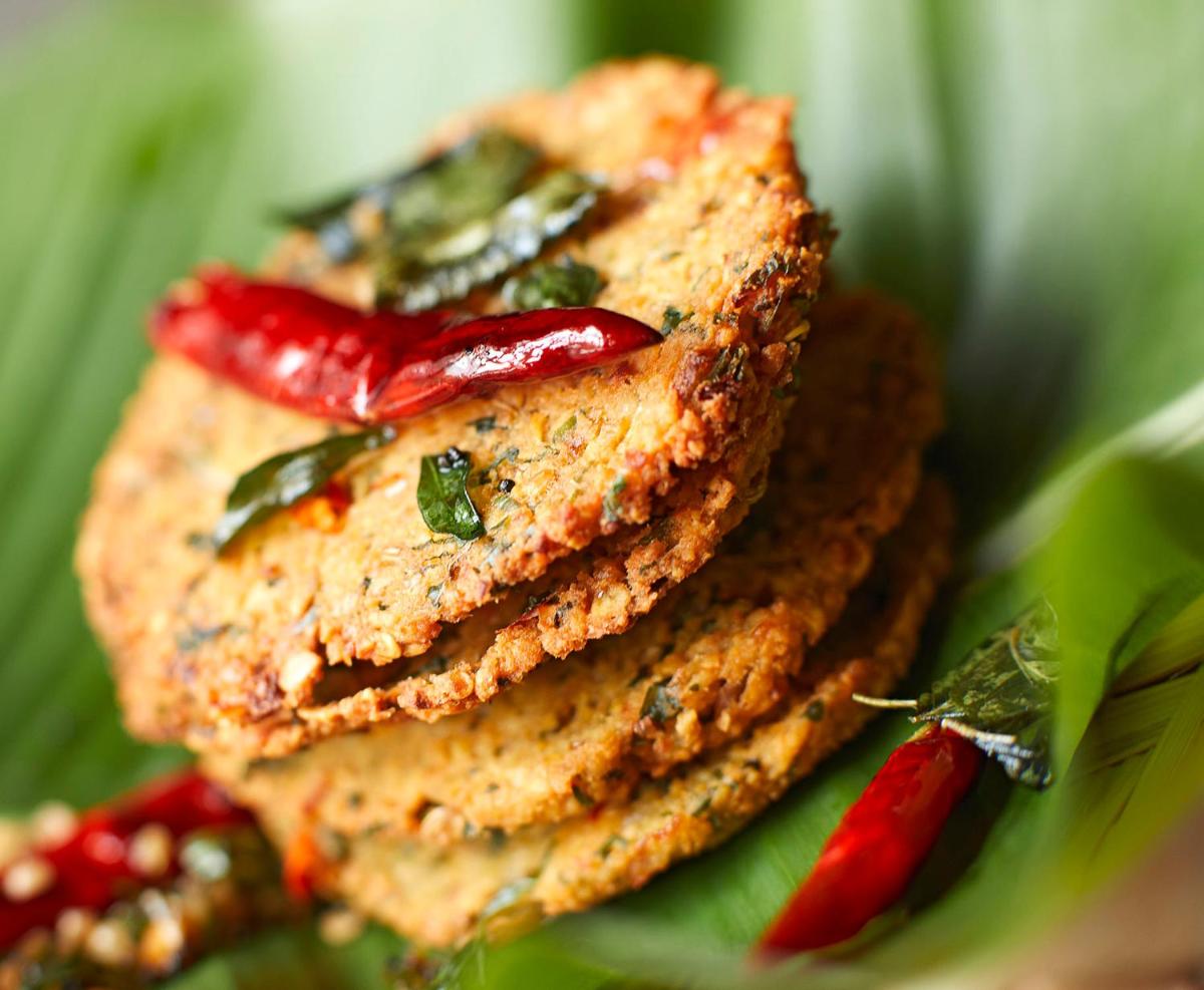 a stack of food on a green plate with peppers at Taj Tirupati in Tirupati