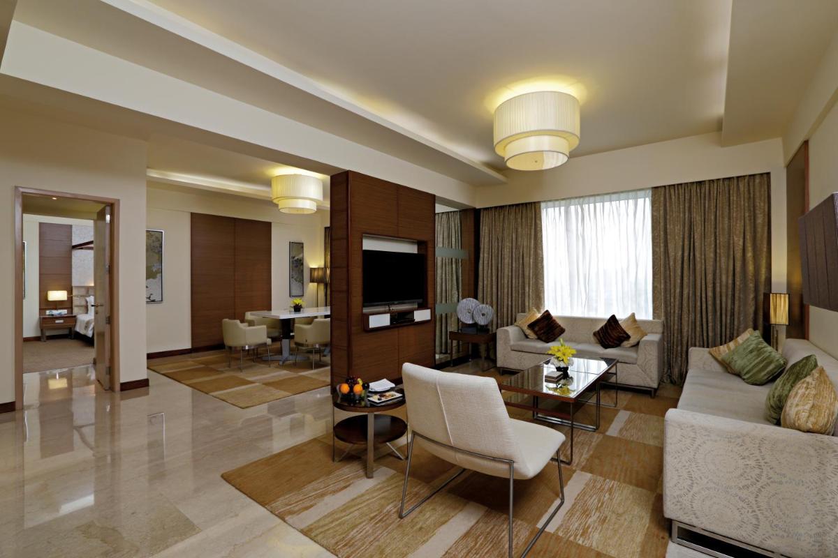 a living room with a couch and a table at Radisson Blu Hotel, Greater Noida in Greater Noida