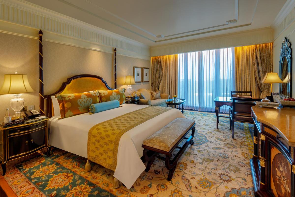 a bedroom with a large bed and a living room at The Leela Palace New Delhi in New Delhi a bedroom with a large bed and a living room at The Leela Palace New Delhi in New Delhi