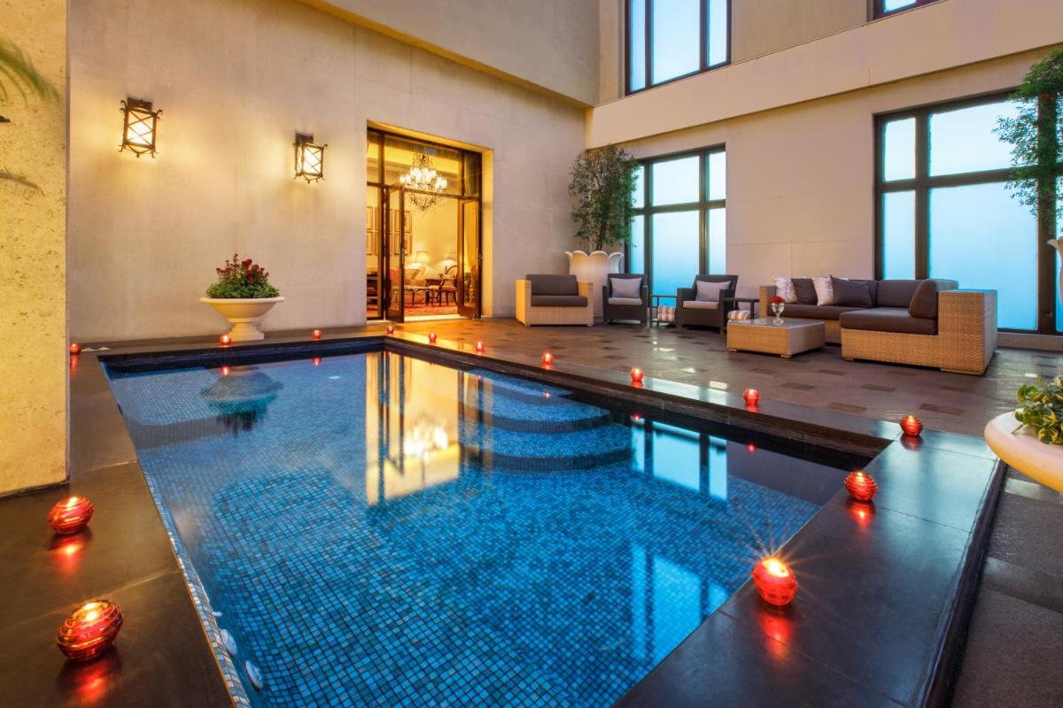 a swimming pool in a house with a living room at The Leela Palace New Delhi in New Delhi a swimming pool in a house with a living room at The Leela Palace New Delhi in New Delhi