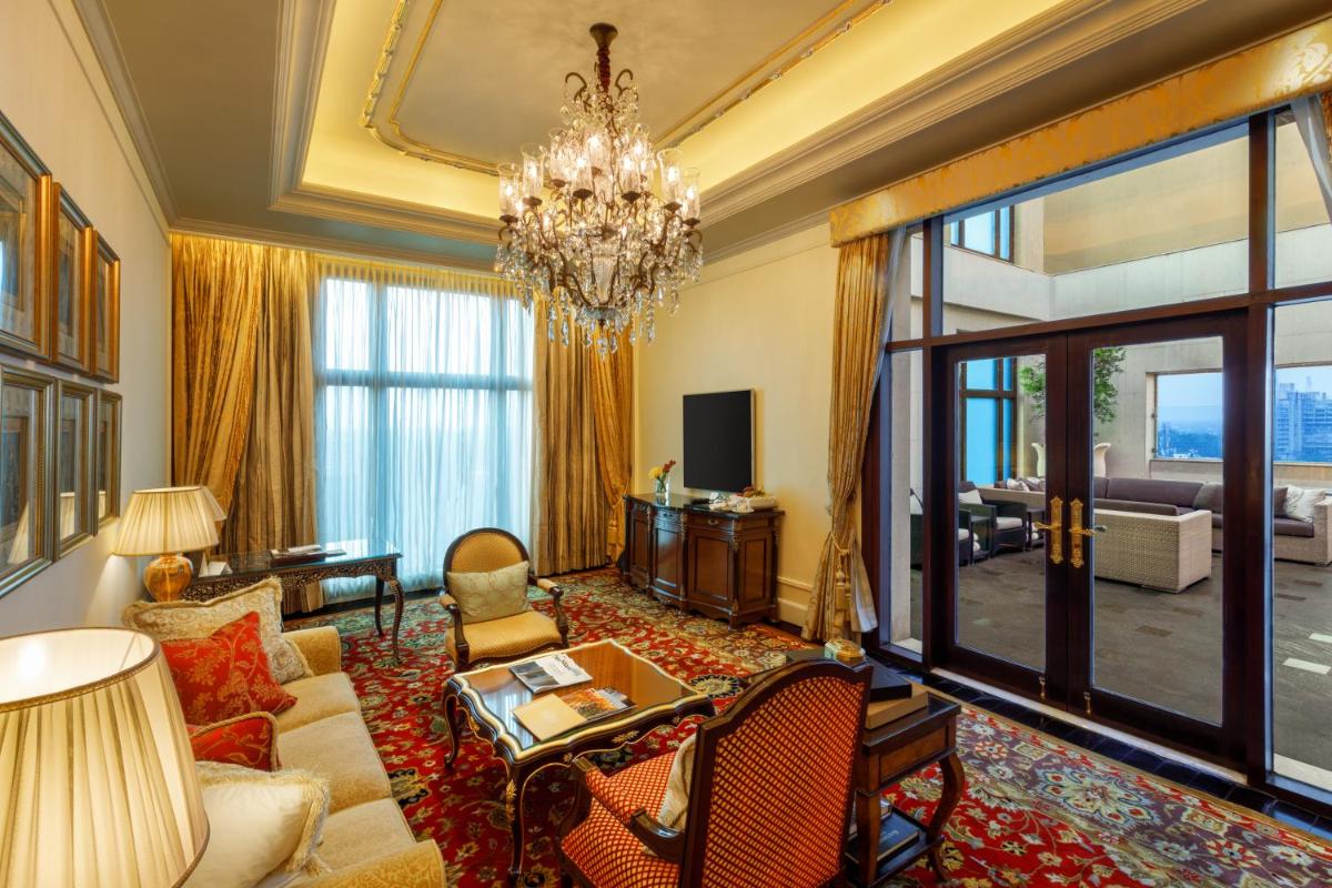 a living room with a chandelier and a large window at The Leela Palace New Delhi in New Delhi a living room with a chandelier and a large window at The Leela Palace New Delhi in New Delhi